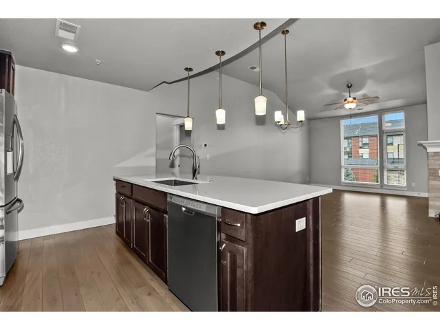 a kitchen with a sink a counter space and wooden floor