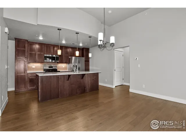 a kitchen with stainless steel appliances granite countertop a sink a stove and a refrigerator