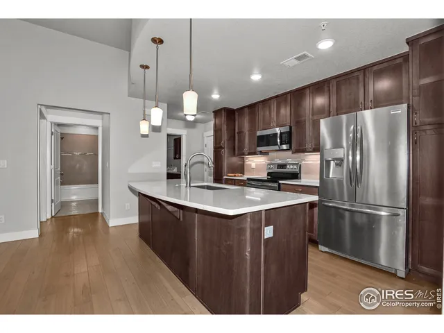 a kitchen with kitchen island a sink stainless steel appliances and cabinets