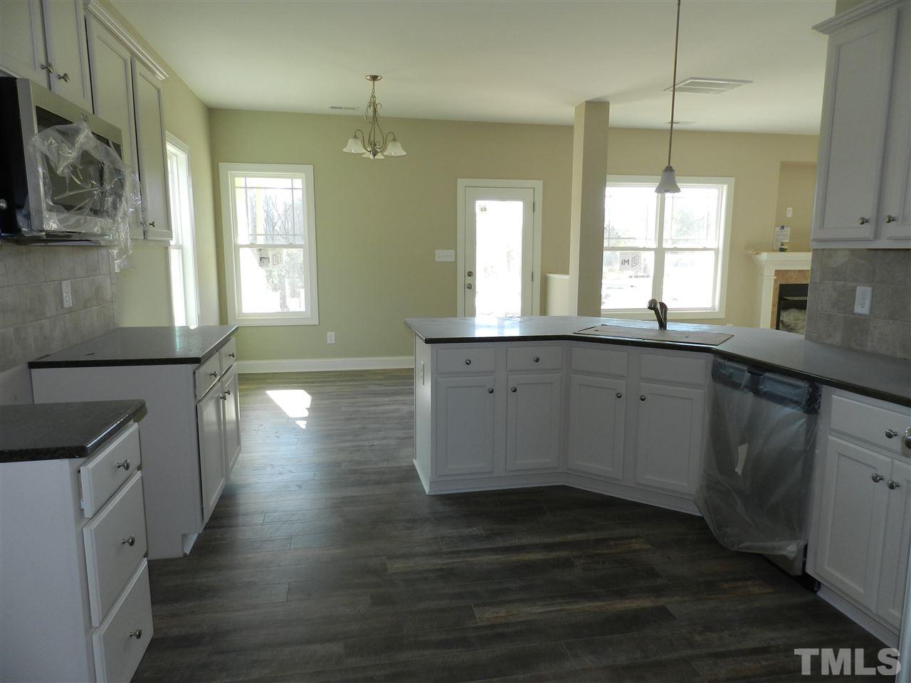 19 Labradoodle Court Garner, NC 27529 - Photo 6 of 9 a kitchen with stainless steel appliances granite countertop a sink a stove and a wooden floors