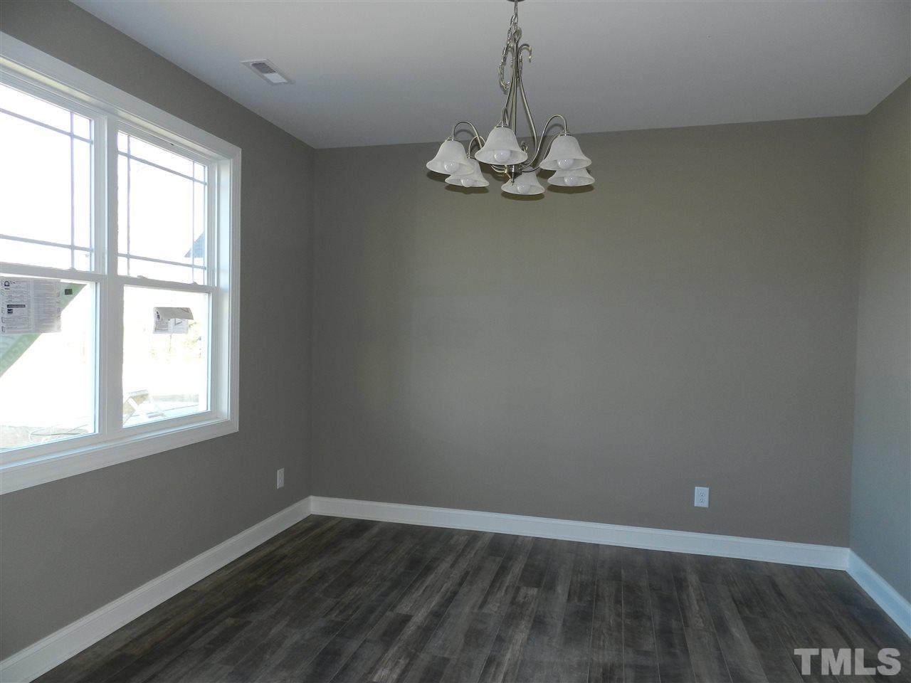 19 Labradoodle Court Garner, NC 27529 - Photo 7 of 9 an empty room with wooden floor and window