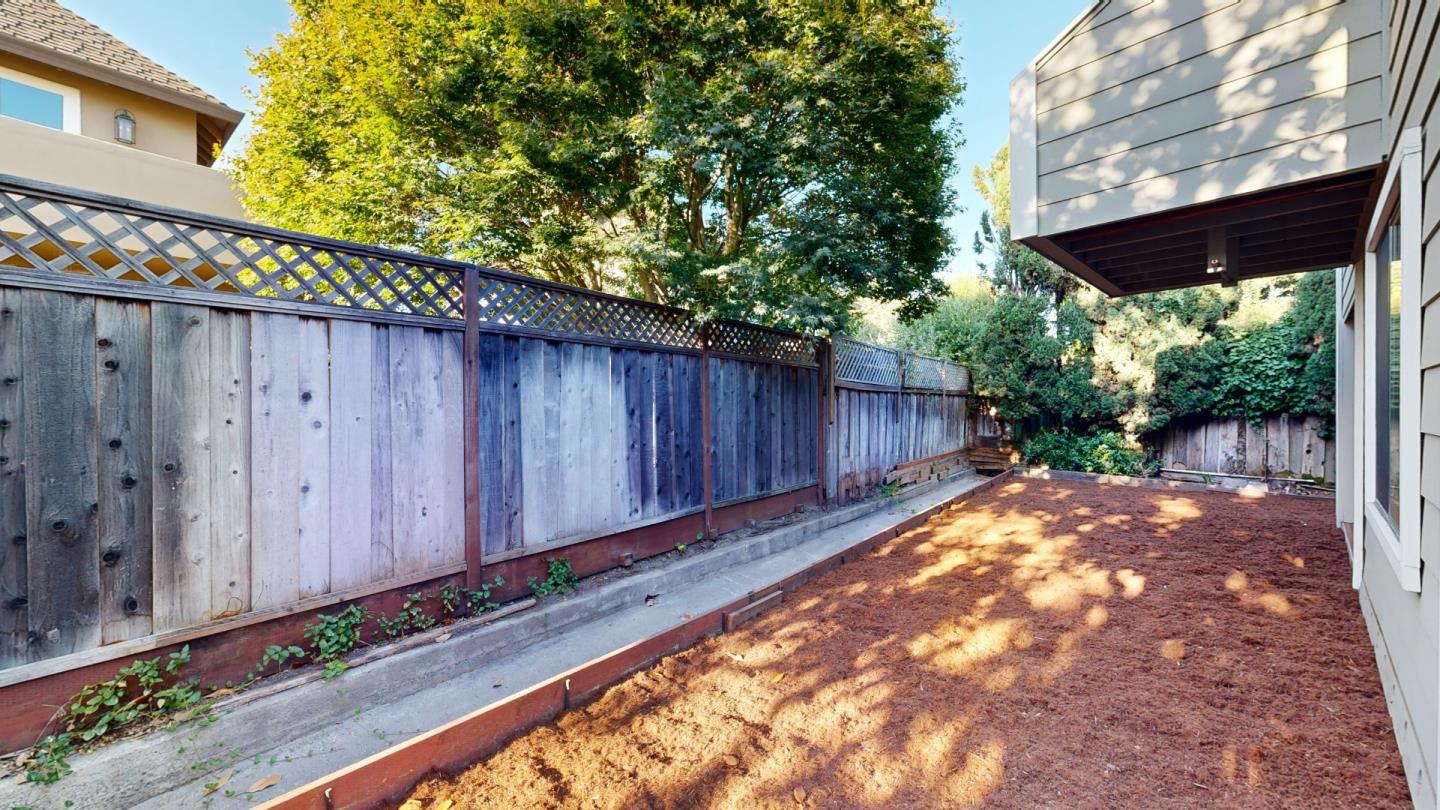 4493 Merlin Way Soquel, CA 95073 - Photo 23 of 52 a view of a backyard with a large tree and wooden fence