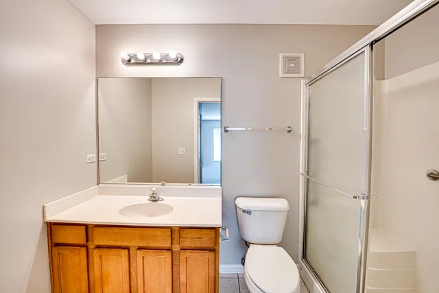 a bathroom with a sink a toilet a mirror and shower