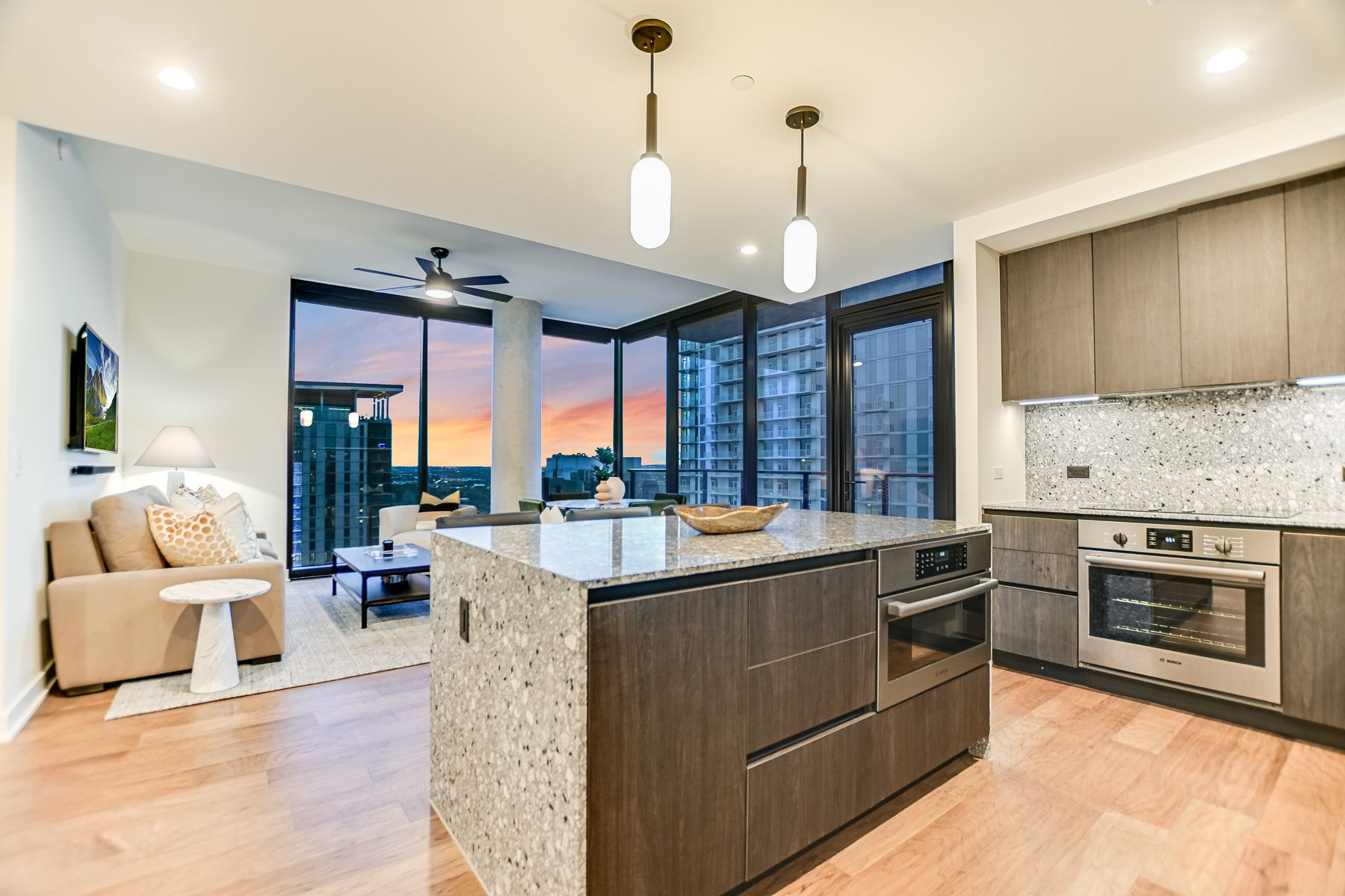 84 East Avenue, Unit 3909 Austin, TX 78701 - Photo 25 of 26 Kitchen with light stone countertops, modern cabinets, a center island, open floor plan, and expansive windows