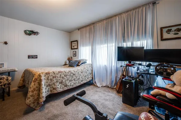 a bedroom with bed and a flat tv screen on the dresser