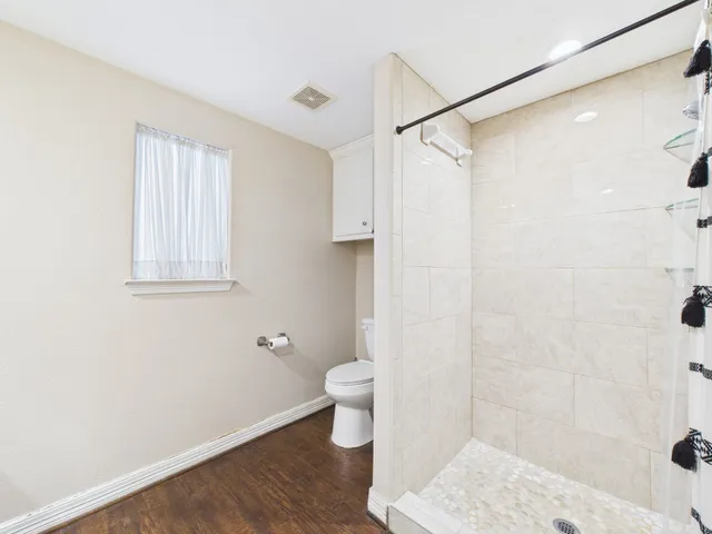 a bathroom with a toilet and a shower