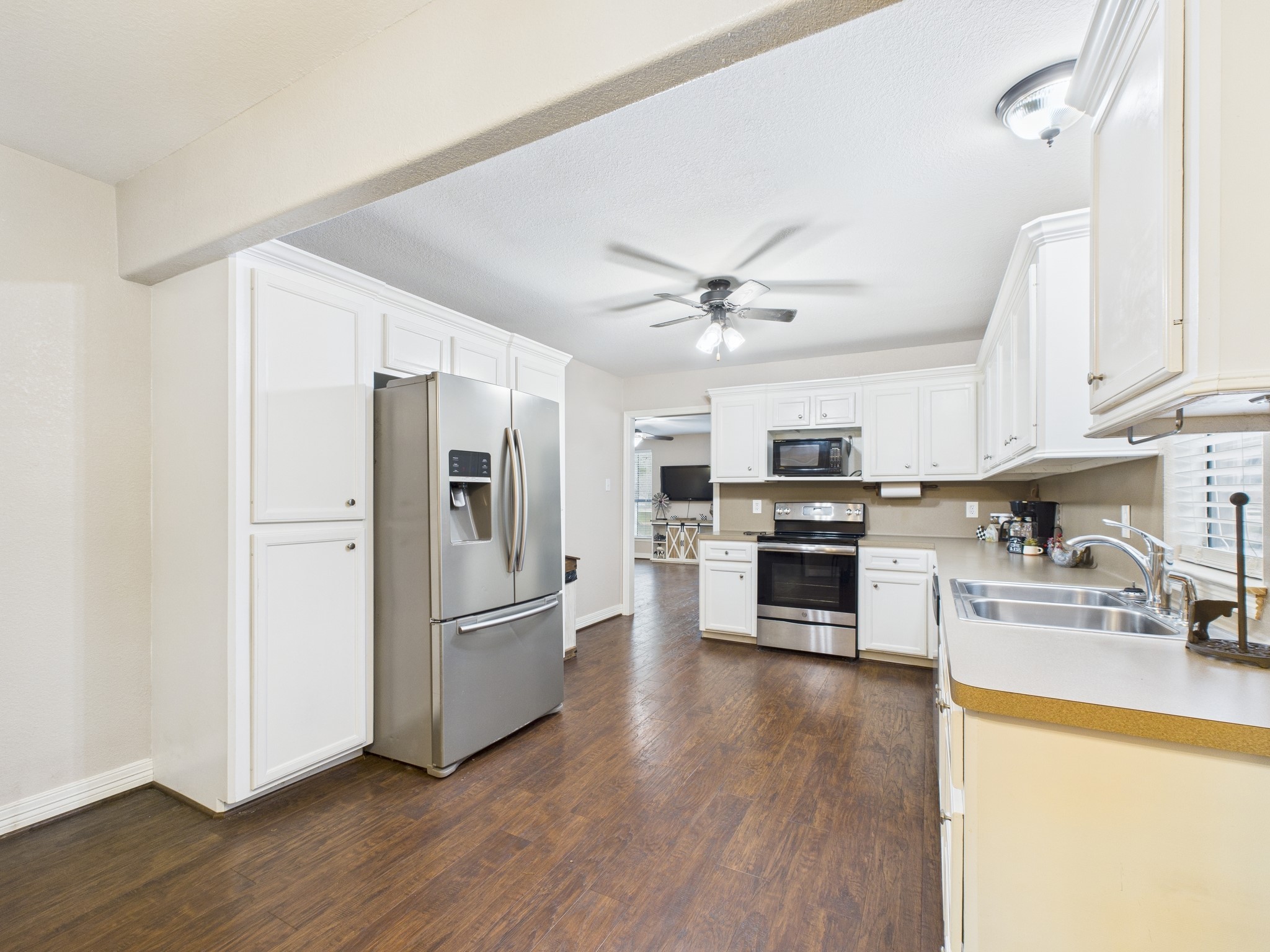 15802 Firetower Road, Unit A Conroe, TX 77306 - Photo 7 of 17 a kitchen with stainless steel appliances granite countertop a refrigerator a stove oven and a sink with wooden floor