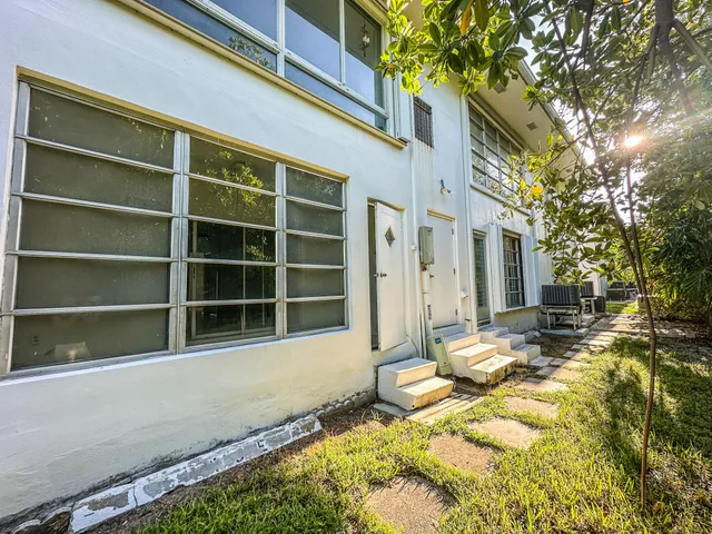 a view of a house with a yard and sitting area