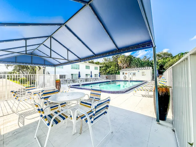 a view of patio with table and chairs under an umbrella