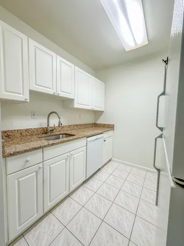 a kitchen with a sink window and cabinets