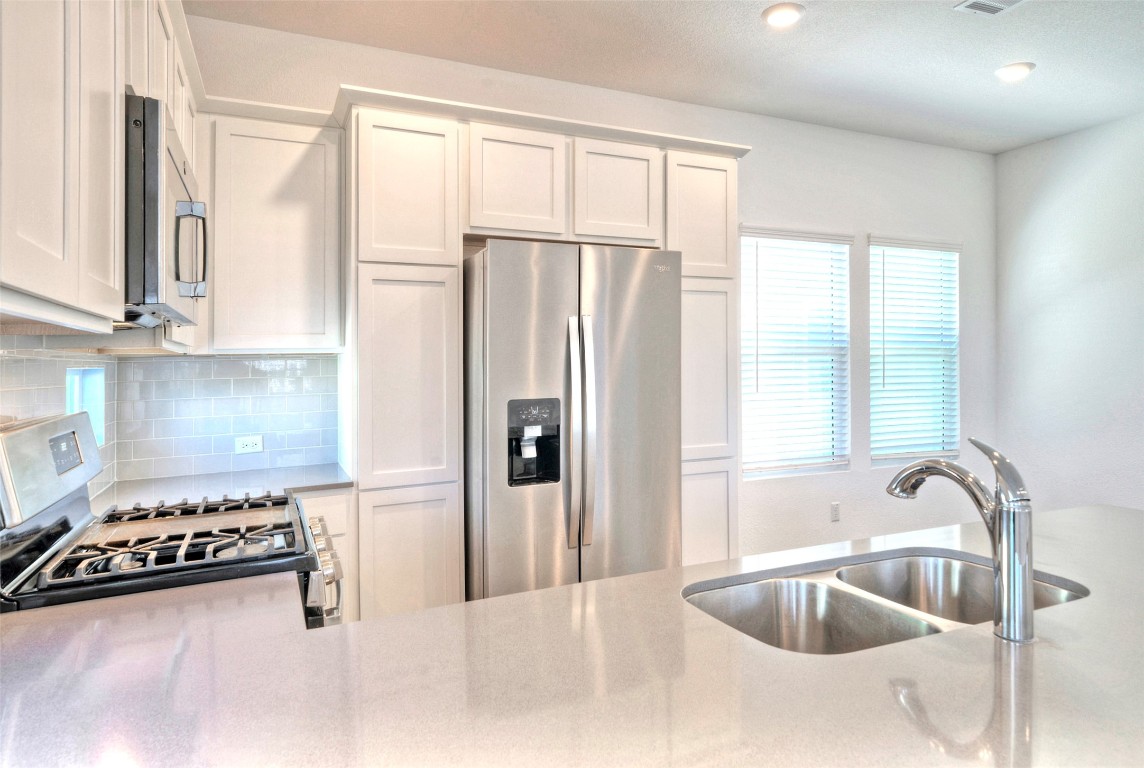 201 Rioja Kyle, TX 78640 - Photo 5 of 21 a kitchen with stainless steel appliances granite countertop a sink a stove and a refrigerator