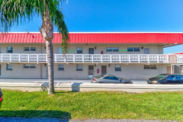 a view of swimming pool with a yard and palm trees
