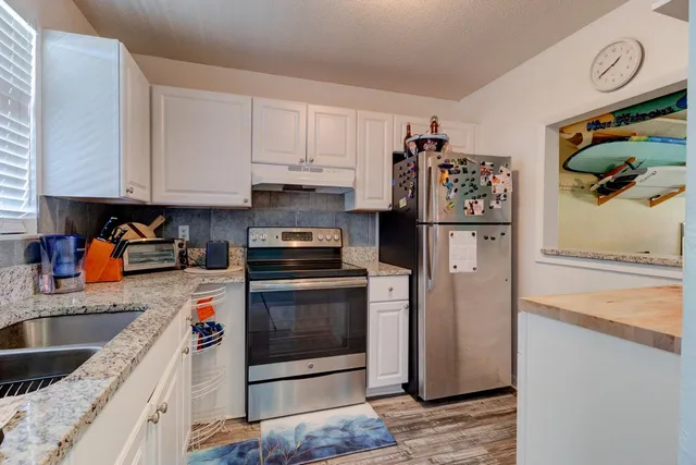 a kitchen with stainless steel appliances granite countertop a refrigerator sink and stove