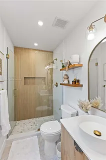a bathroom with a sink a toilet and shower