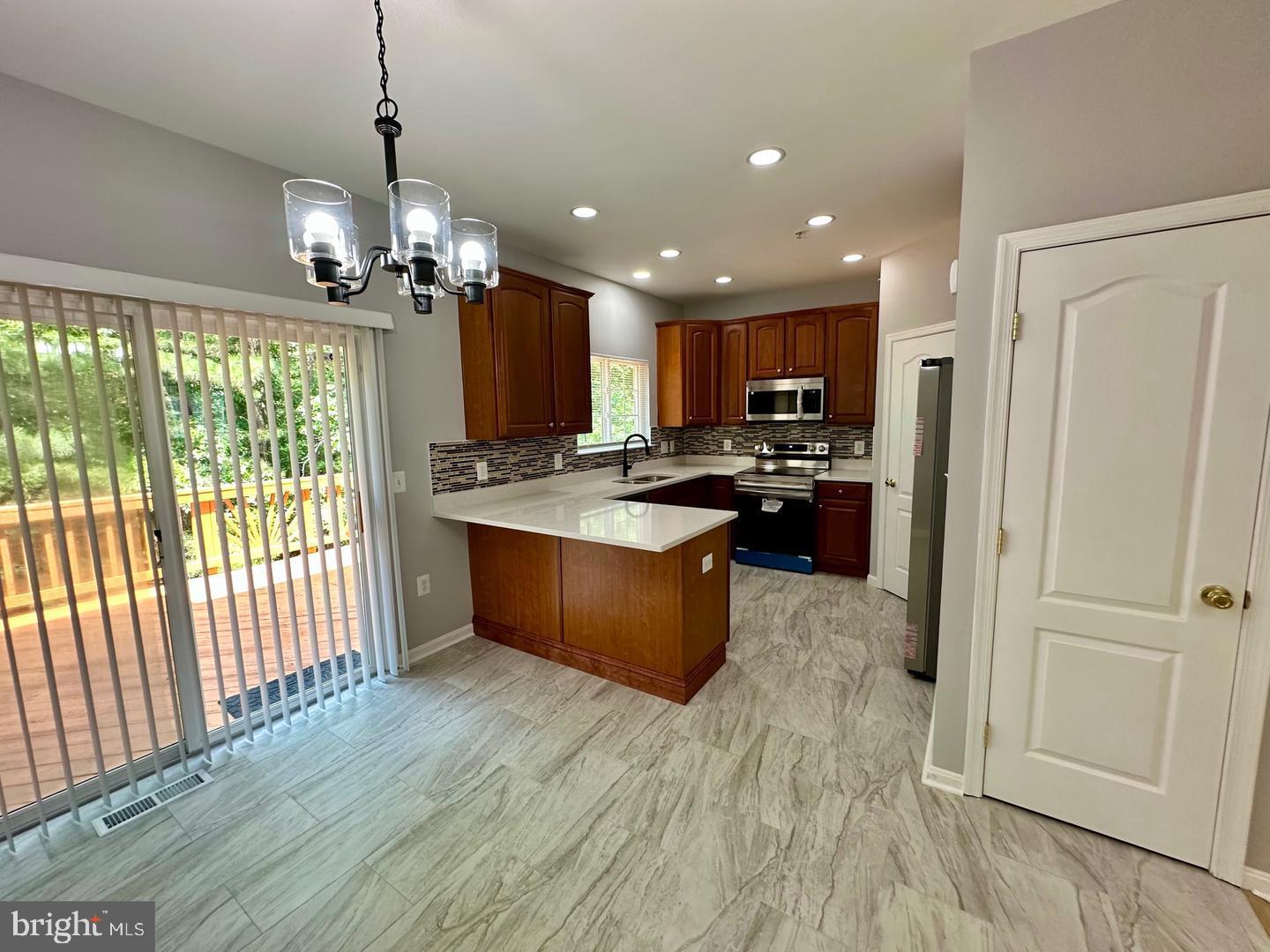 15503 Kennett Square Way Brandywine, MD 20613 - Photo 6 of 32 a kitchen with stainless steel appliances granite countertop a refrigerator a oven a sink dishwasher and a stove with wooden floor