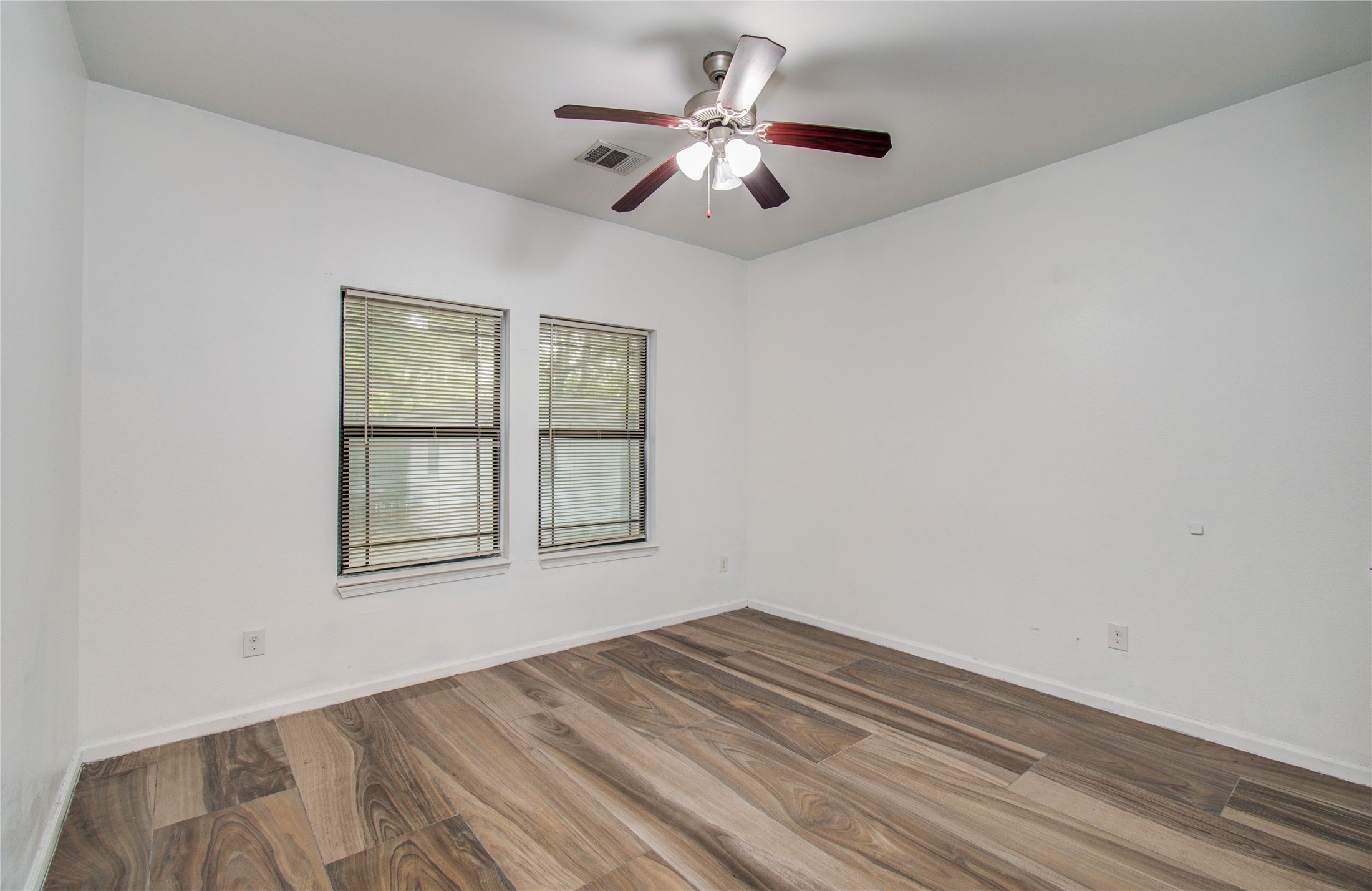 8040 Howton Street, Unit 12 Houston, TX 77028 - Photo 12 of 35 a view of empty room with wooden floor and fan