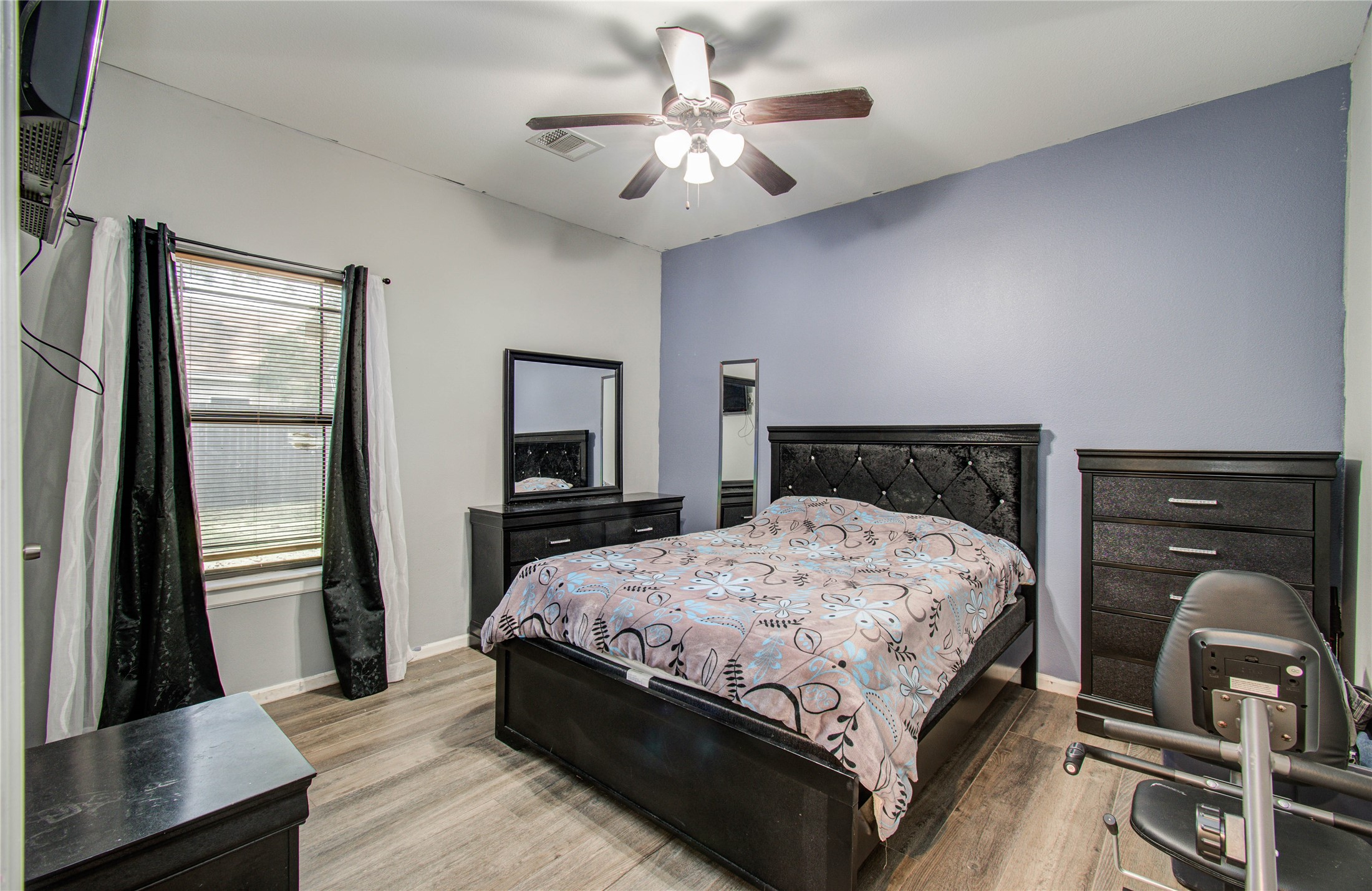 8040 Howton Street, Unit 12 Houston, TX 77028 - Photo 30 of 35 a bedroom with a bed a mirror on dresser and a chandelier