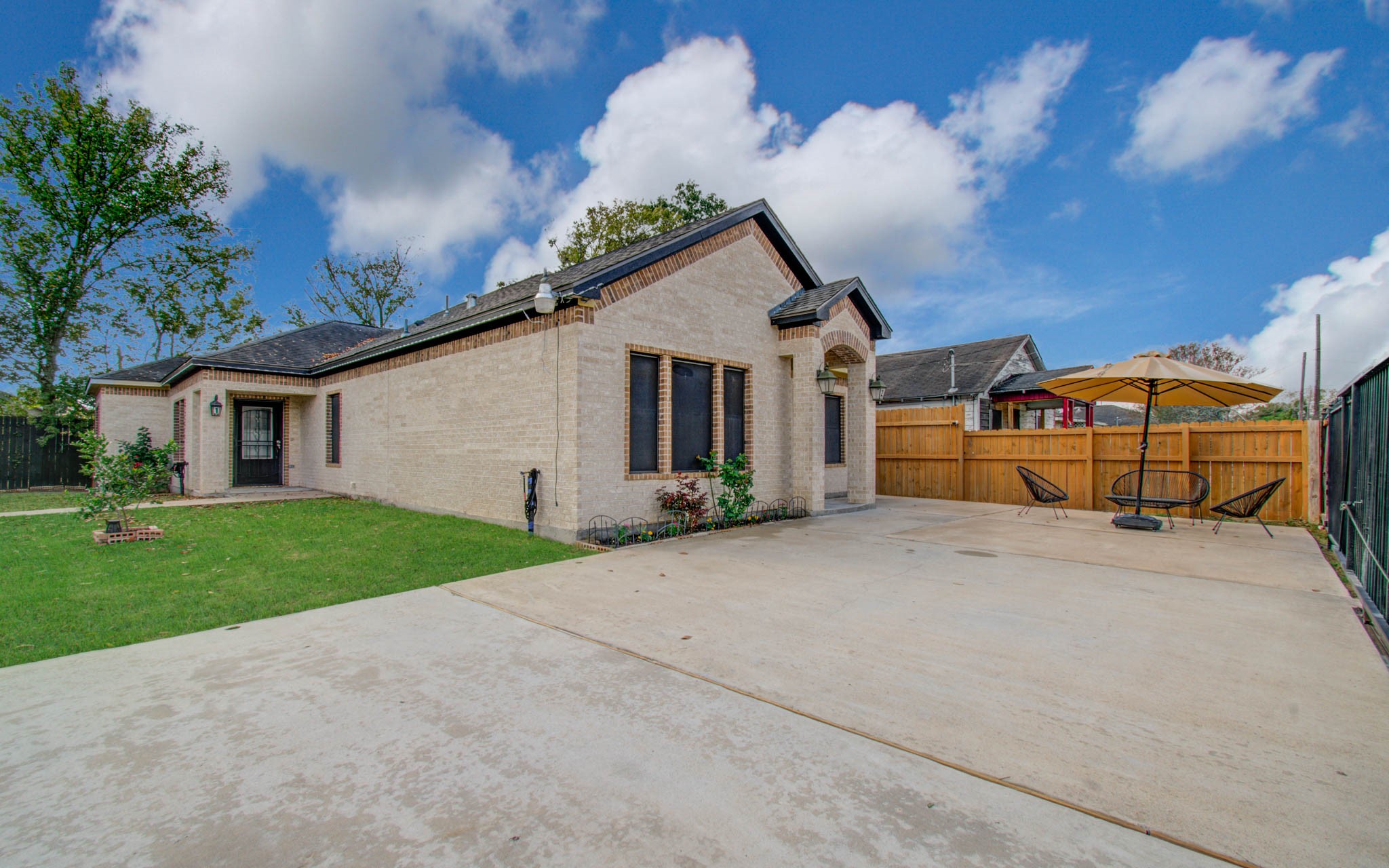 8040 Howton Street, Unit 12 Houston, TX 77028 - Photo 34 of 35 a yellow house with a big yard and large trees