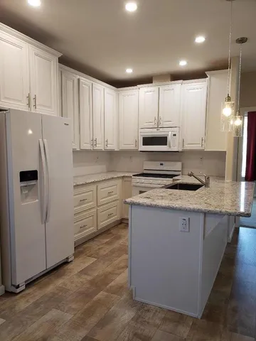 a kitchen with stainless steel appliances granite countertop a refrigerator sink and cabinets