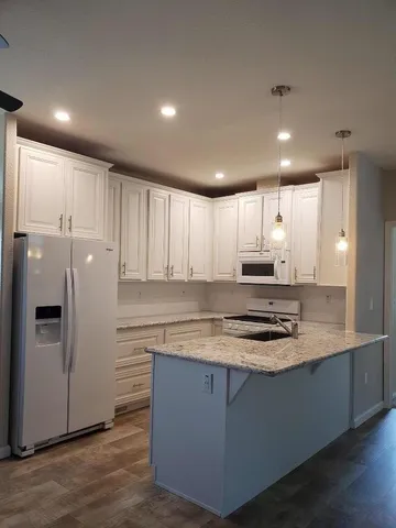 a kitchen with a sink a stove a refrigerator and chandelier