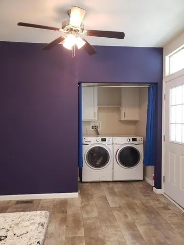 an empty room with windows and fan