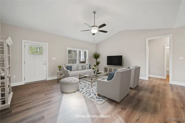 a living room with furniture potted plant and a flat screen tv