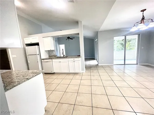 a kitchen with granite countertop a stove a sink and a refrigerator