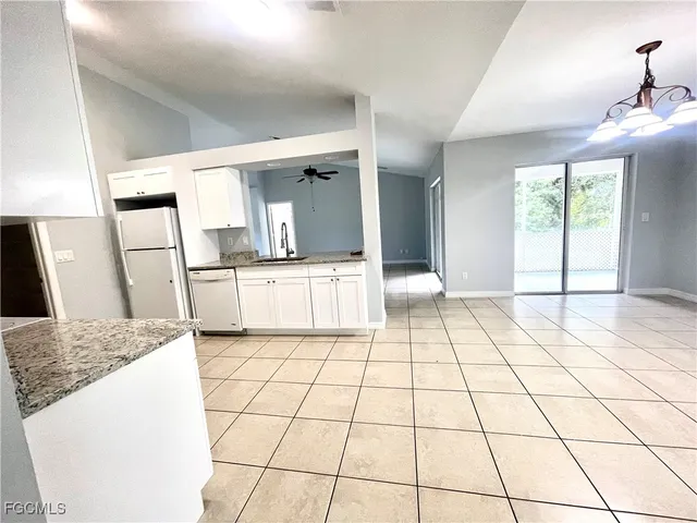 a kitchen with granite countertop a stove a sink and a refrigerator