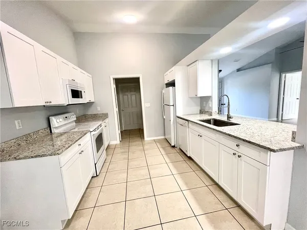 a large kitchen with a stove a sink and a refrigerator