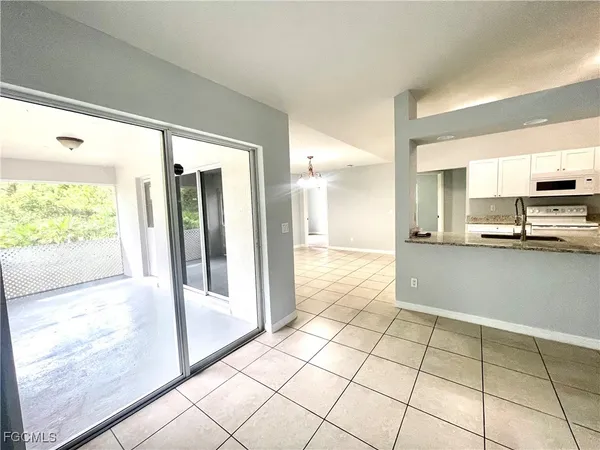 a view of a kitchen with kitchen island granite countertop a refrigerator and a sink