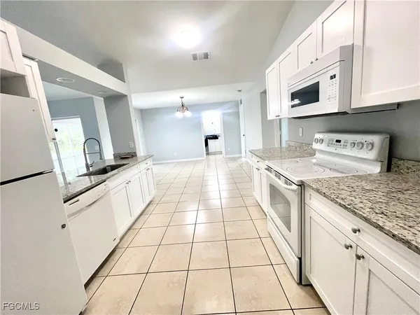 a large white kitchen with cabinets