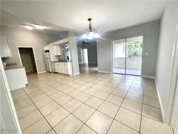 a view of a room with a chandelier fan and windows