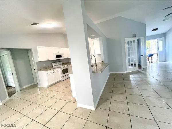 a view of a kitchen with furniture and an empty room