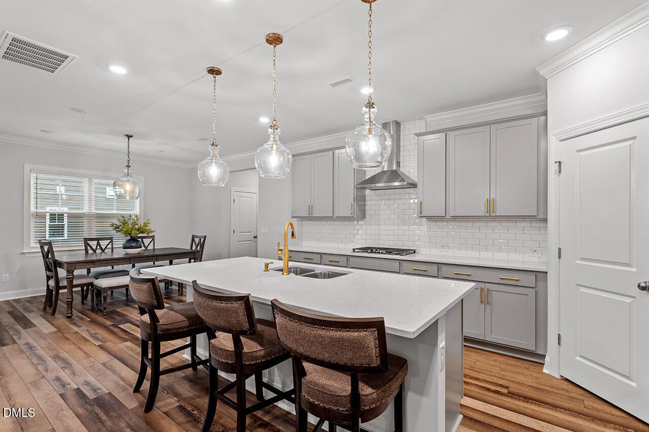3932 Mount Moran Road Raleigh, NC 27616 - Photo 13 of 40 a kitchen with a dining table chairs wooden floor cabinets and appliances