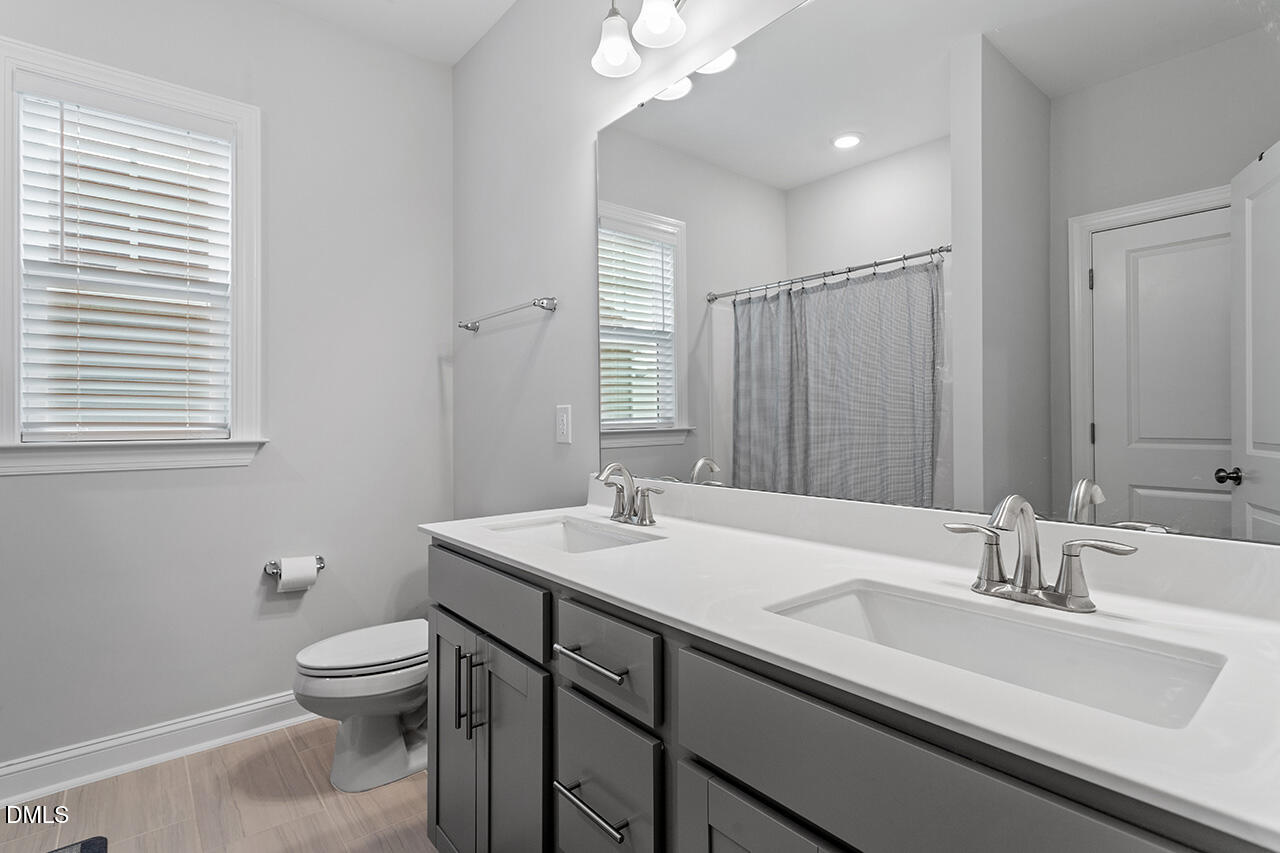 3932 Mount Moran Road Raleigh, NC 27616 - Photo 33 of 40 a bathroom with a sink toilet and mirror