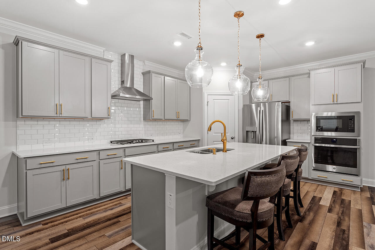 3932 Mount Moran Road Raleigh, NC 27616 - Photo 8 of 40 a kitchen with stainless steel appliances a stove a sink island and a refrigerator