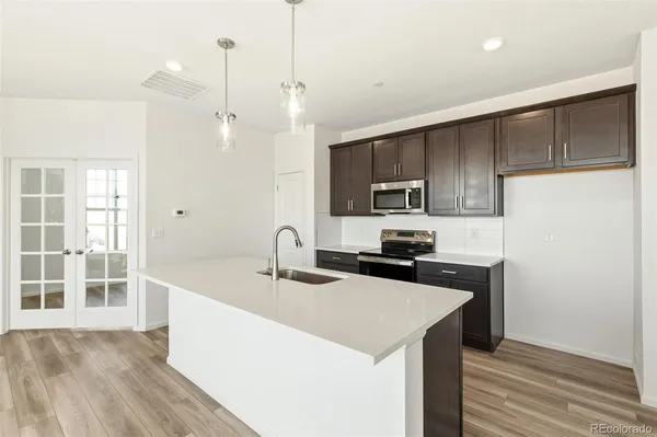a kitchen with kitchen island a sink stainless steel appliances and cabinets