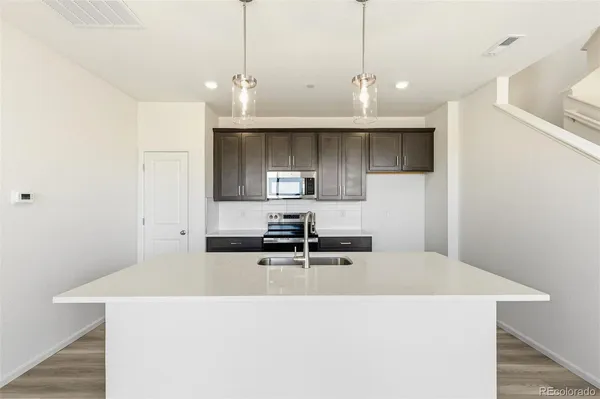 a kitchen with kitchen island a sink stainless steel appliances and cabinets