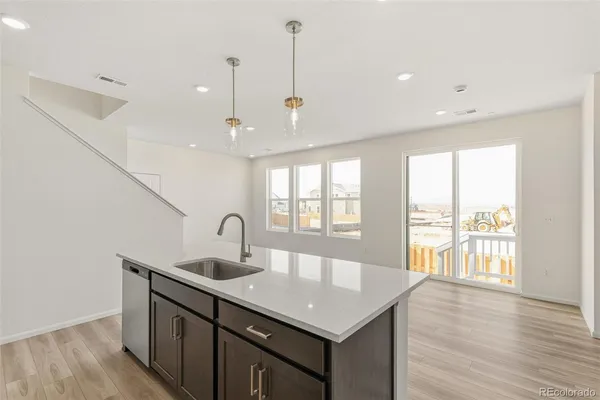 a kitchen with center island wooden floor and a large window