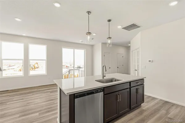 a kitchen with granite countertop a sink cabinets and wooden floor