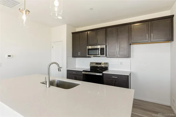 a kitchen with granite countertop a stove top oven sink and cabinets