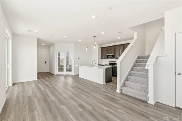 a view of a kitchen with wooden floor and stairs