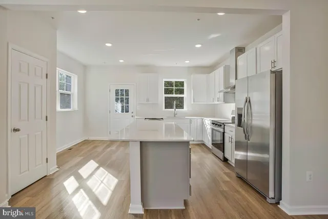 a kitchen with stainless steel appliances granite countertop a refrigerator and a sink