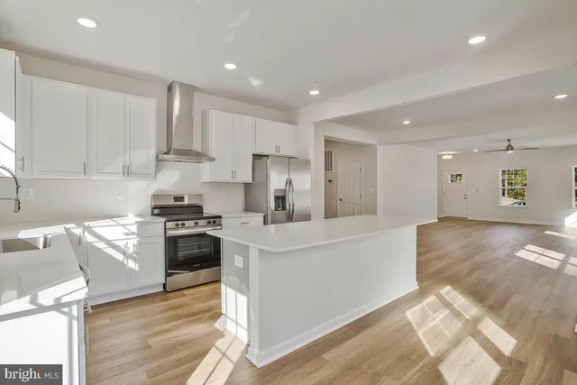 a large kitchen with stainless steel appliances and white cabinets