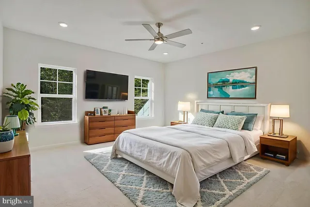 a spacious bedroom with a bed and a flat screen television