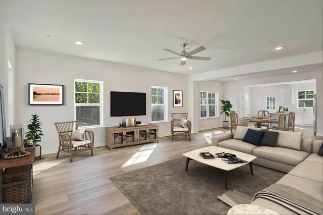 a living room with furniture flat screen tv and wooden floor