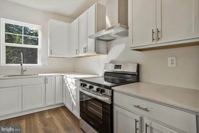 a kitchen with white cabinets and a stove top oven