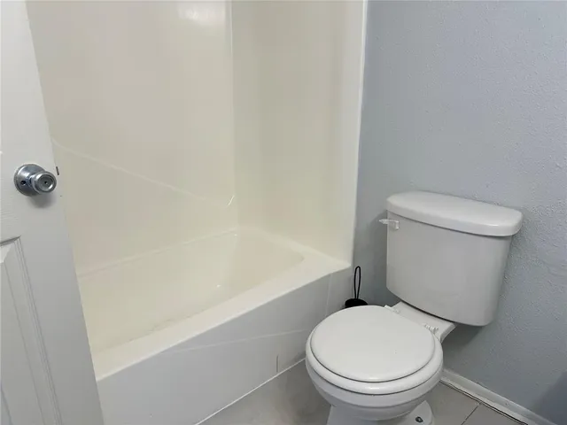 a white toilet sitting next to a bath tub
