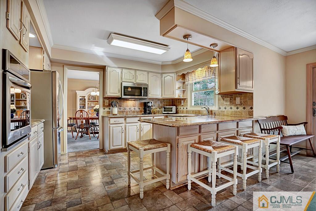 10 Overbrook Road Somerset, NJ 08873 - Photo 8 of 26 a kitchen with stainless steel appliances kitchen island granite countertop a stove top oven a sink a dining table and chairs