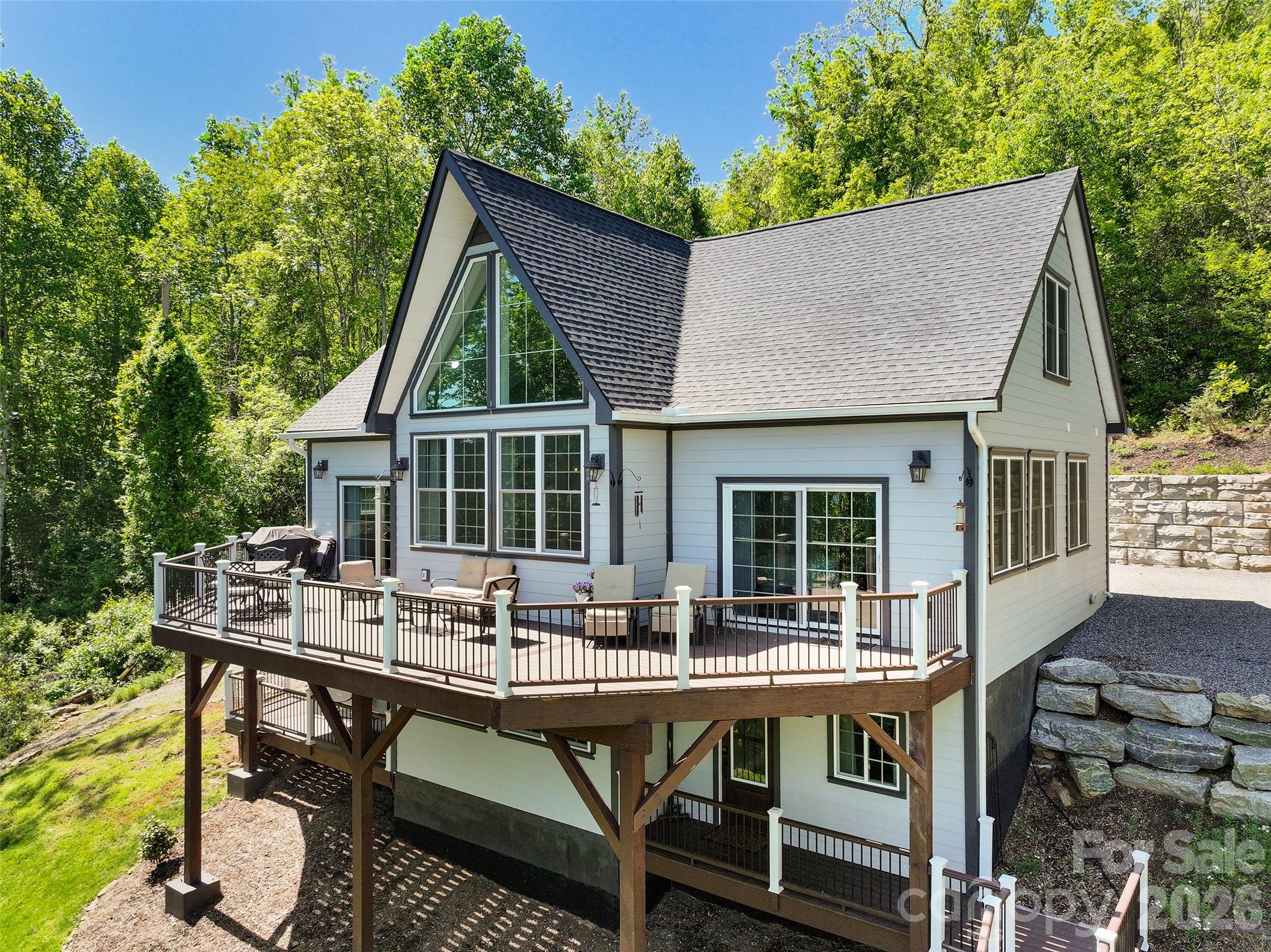 114 Nesting Ridge Waynesville, NC 28785 - Photo 2 of 40 a view of house with a chairs and table in a patio